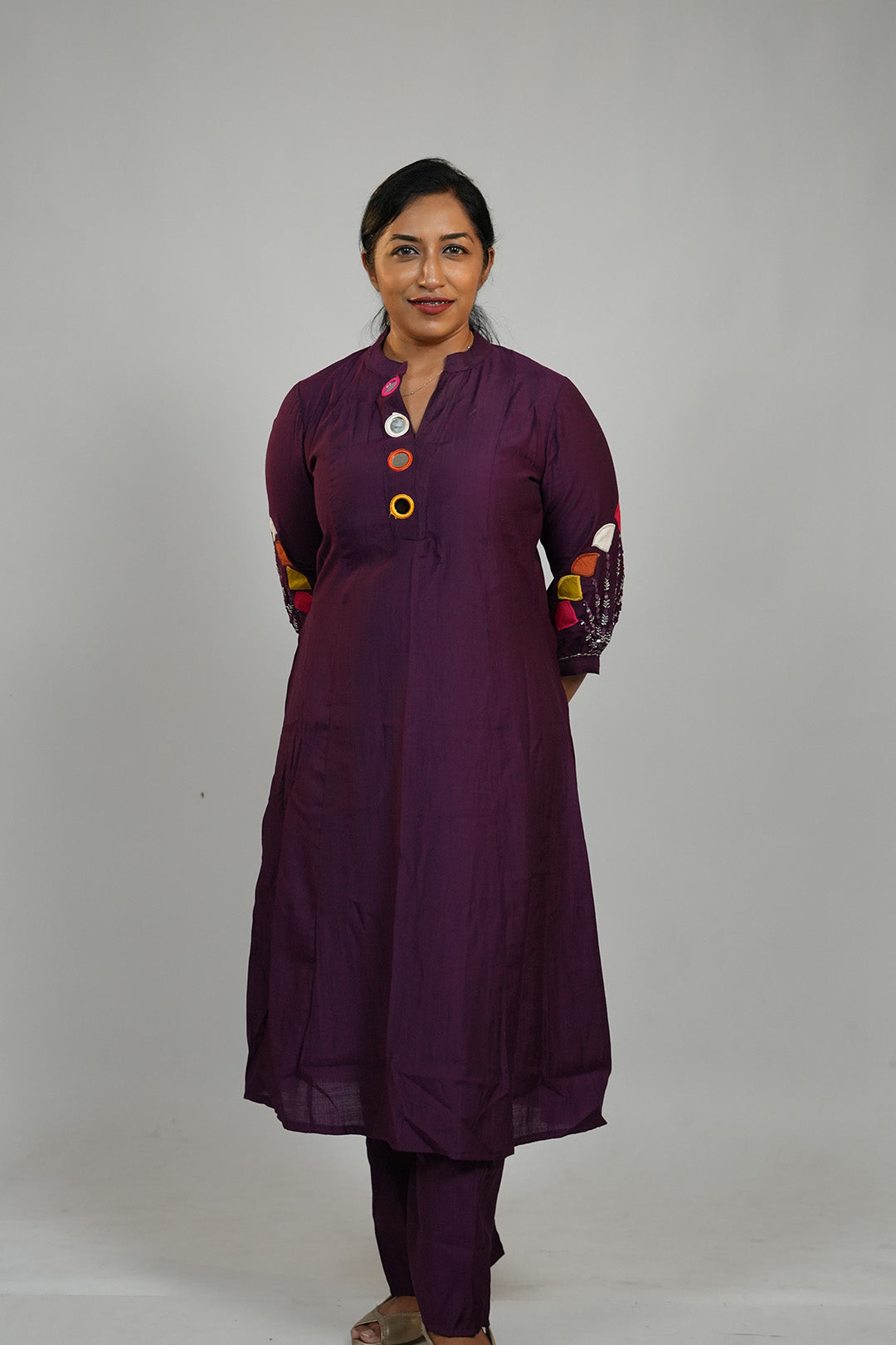 Woman in Aroha Amethyst plum co-ord set standing with hands clasped behind her back