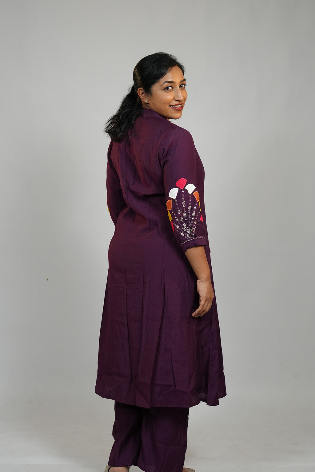 Woman in Aroha Amethyst plum co-ord set posing with an over the shoulder look