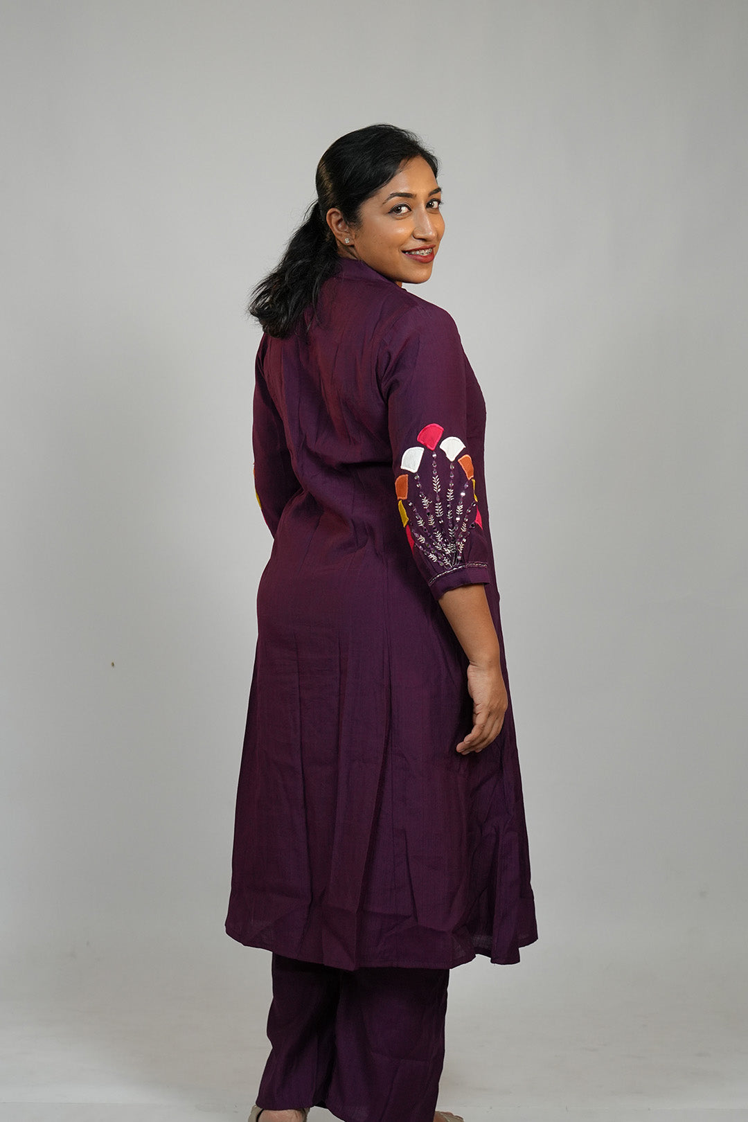 Woman in Aroha Amethyst plum co-ord set posing with an over the shoulder look