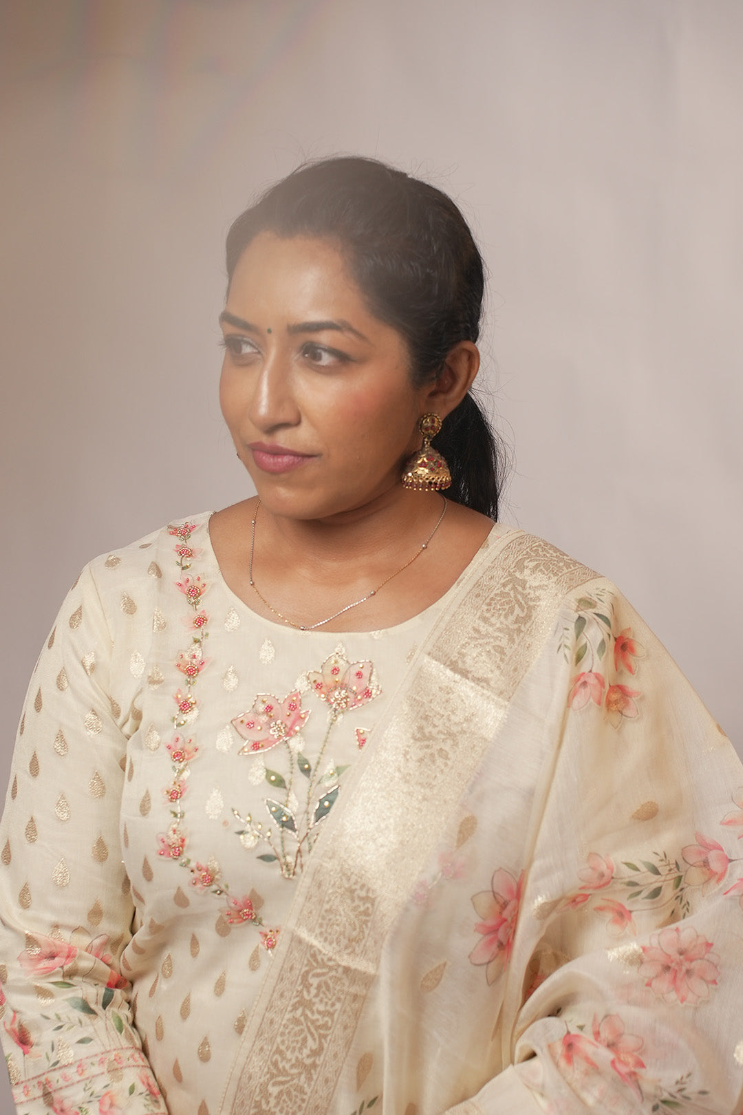 Close up of woman in Aroha Blush Petals co-ord set looking away with soft light flare