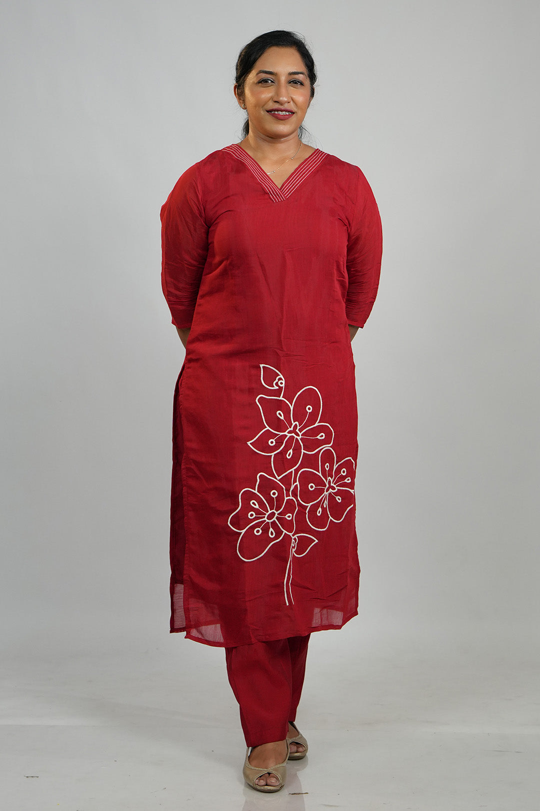 Woman in Aroha Crimson Muse red co-ord set standing with hands clasped behind her back