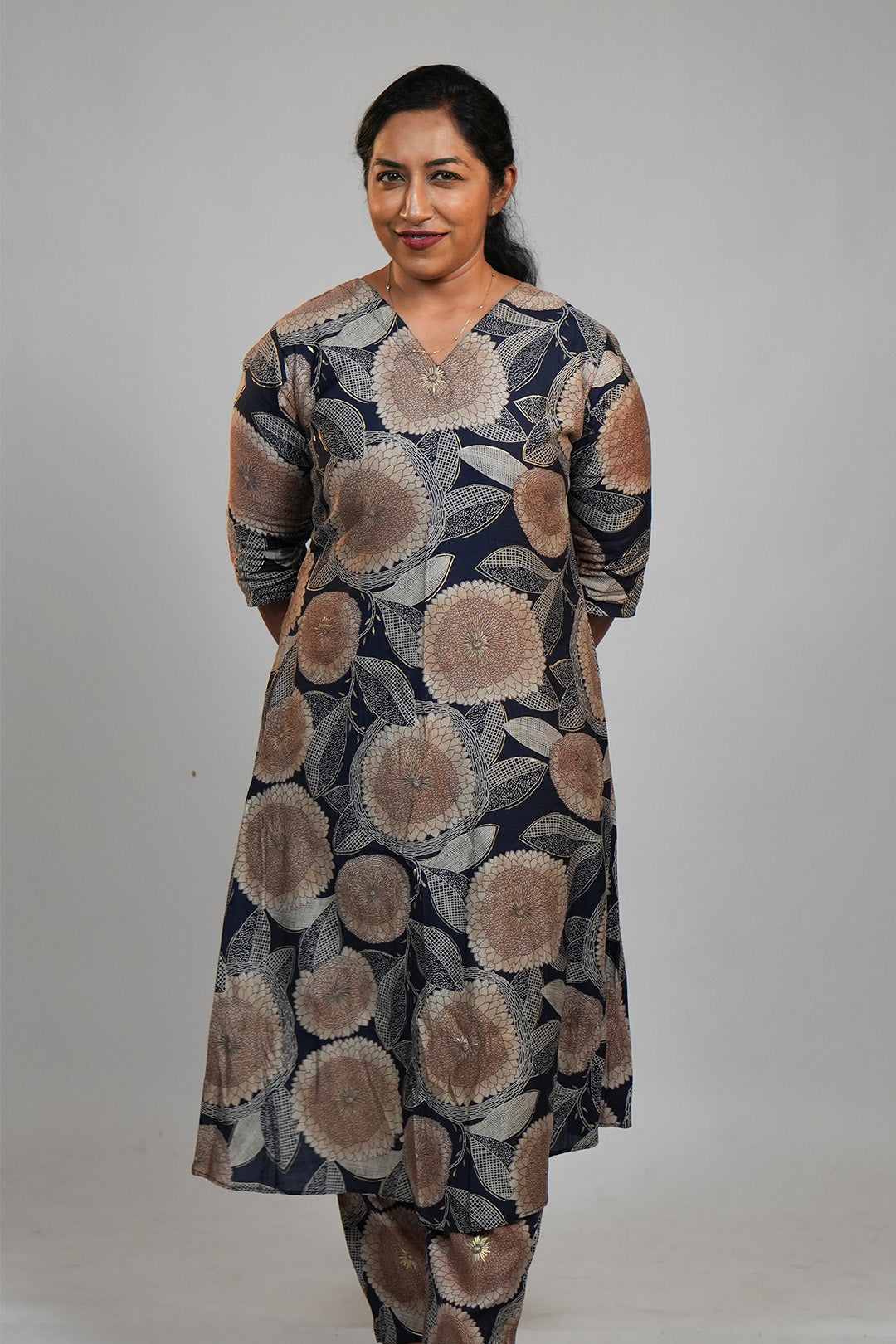 Woman in Aroha Dahlia navy co-ord set standing with hands clasped behind her back