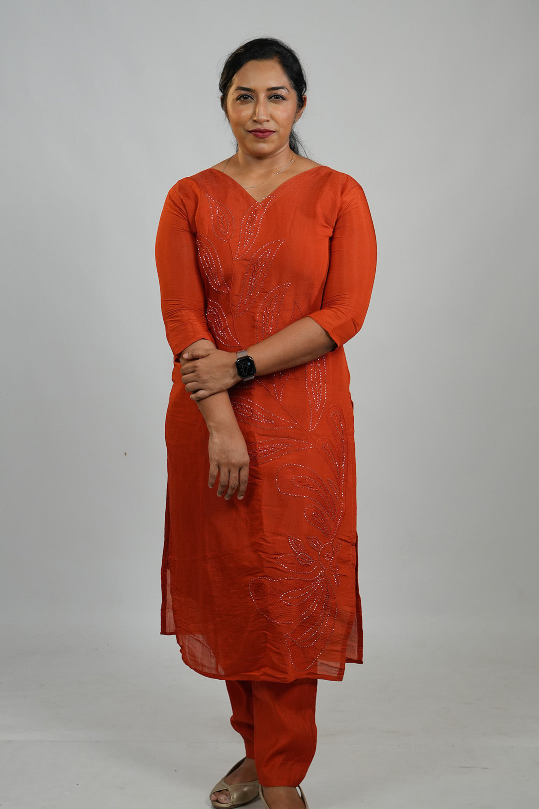 Woman wearing Aroha Ember Leaf terracotta co-ord set with arms crossed