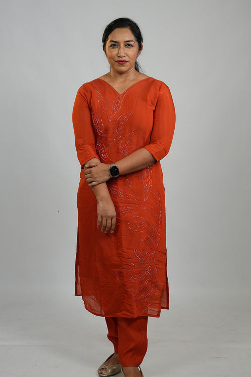 Woman wearing Aroha Ember Leaf terracotta co-ord set with arms crossed