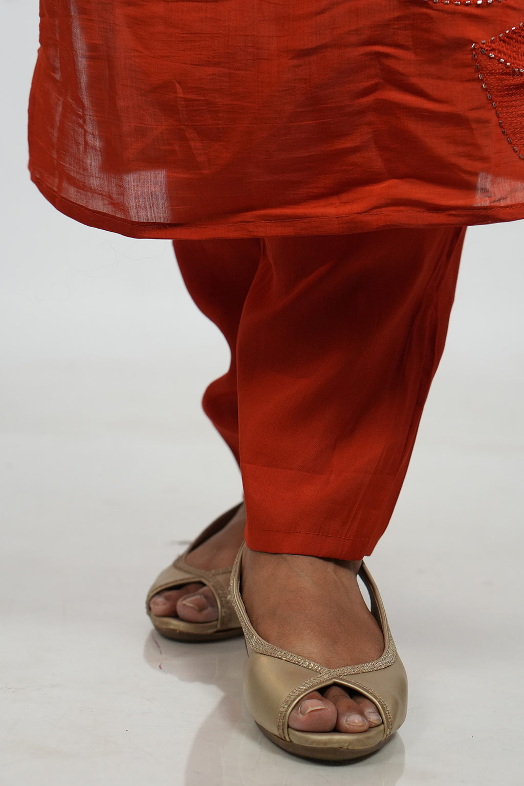 Close up of feet and hem detailing on Aroha Ember Leaf terracotta co-ord set