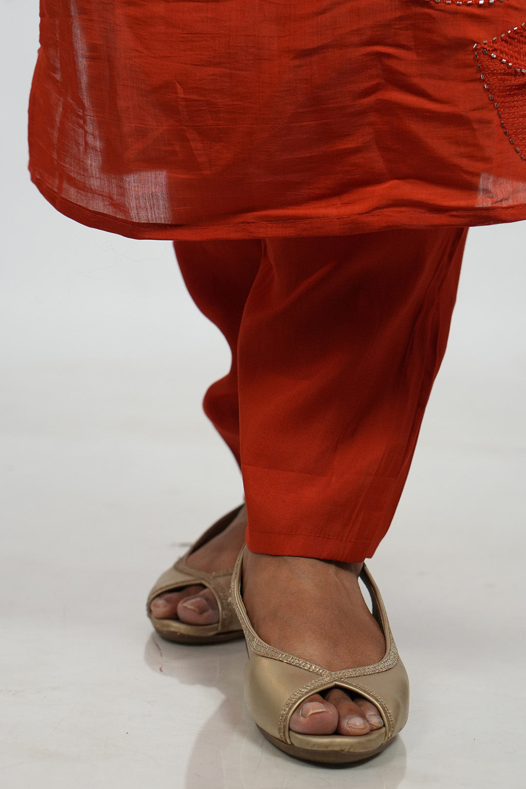 Close up of feet and hem detailing on Aroha Ember Leaf terracotta co-ord set
