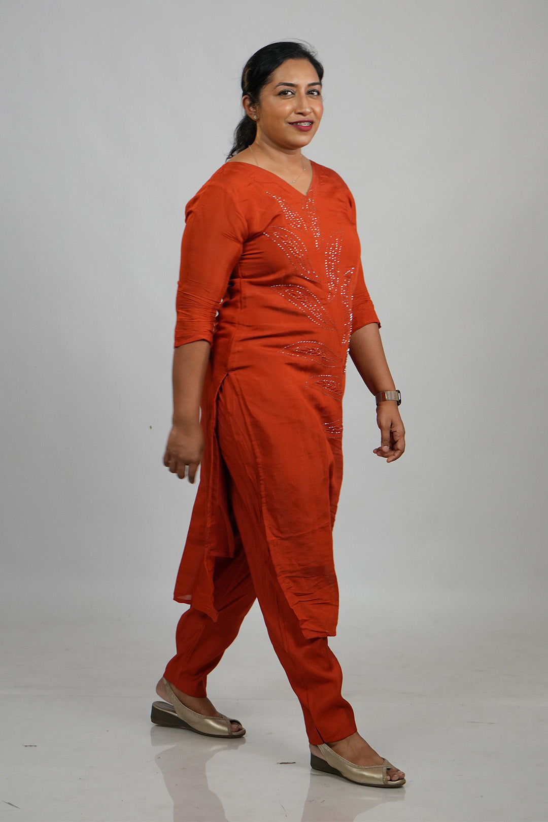 Woman walking candidly in Aroha Ember Leaf terracotta co-ord set