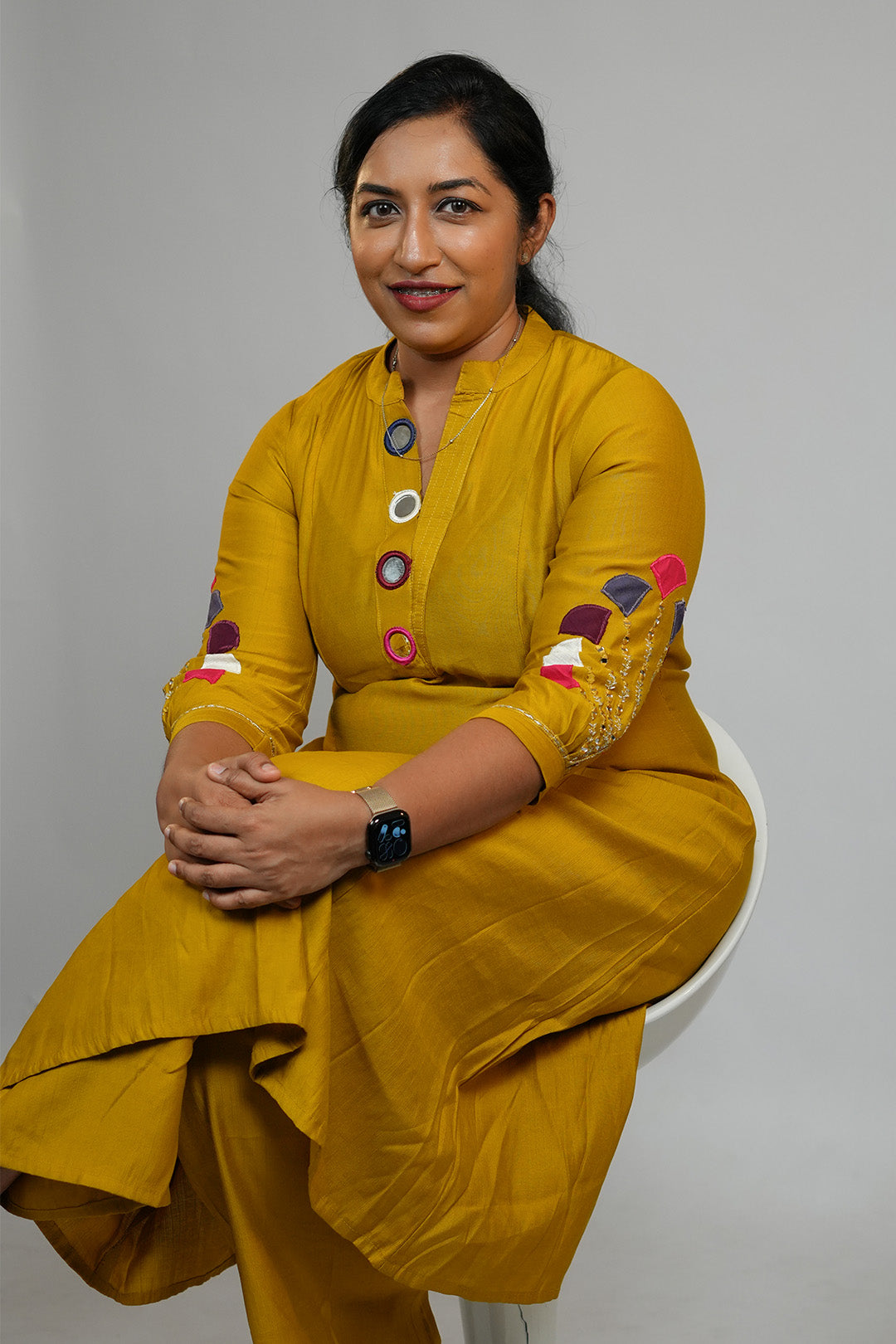 Woman seated wearing Aroha Mustard Muse co-ord set