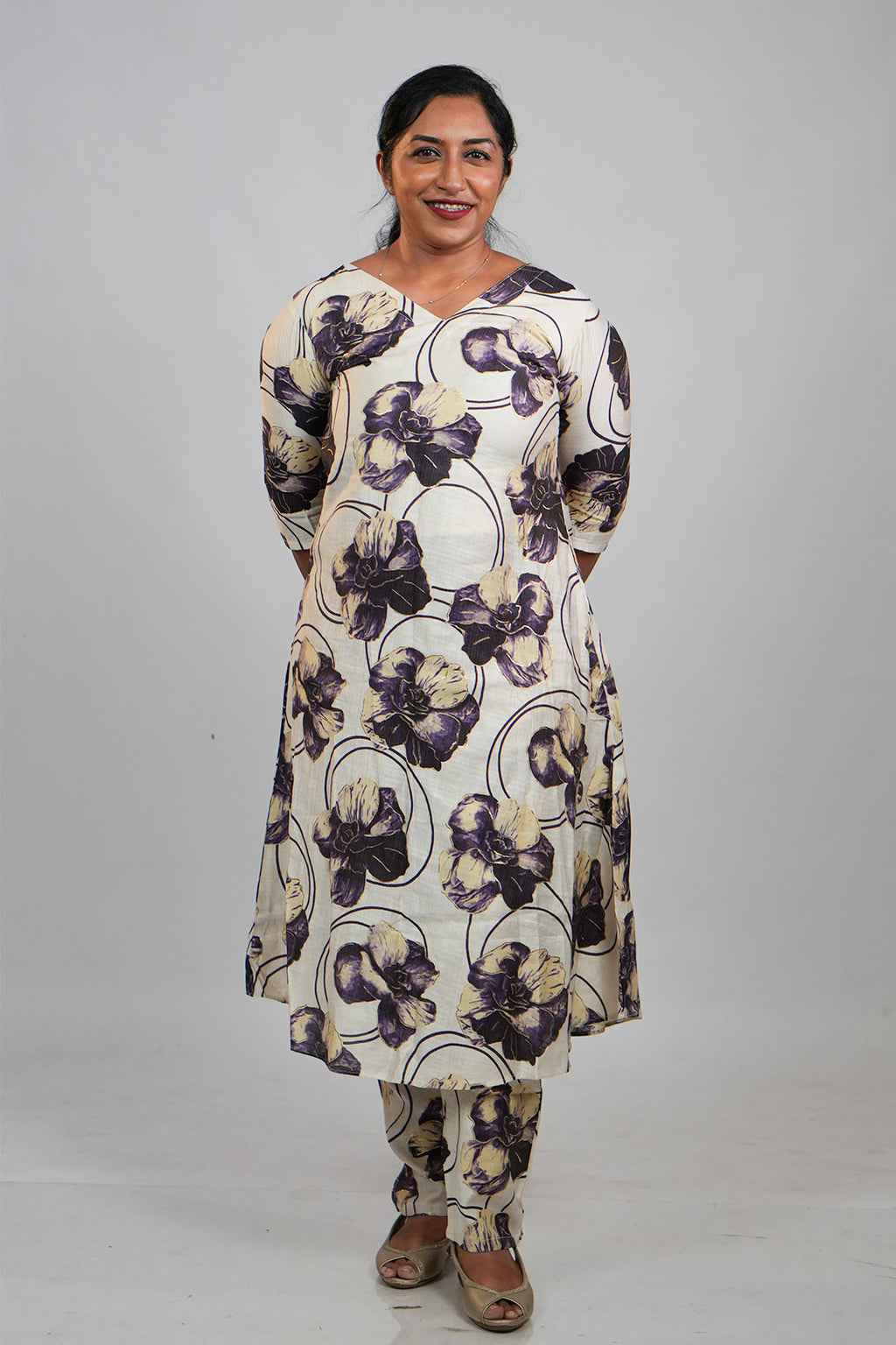Woman in Aroha Orchid Muse co-ord set standing with hands clasped behind her back