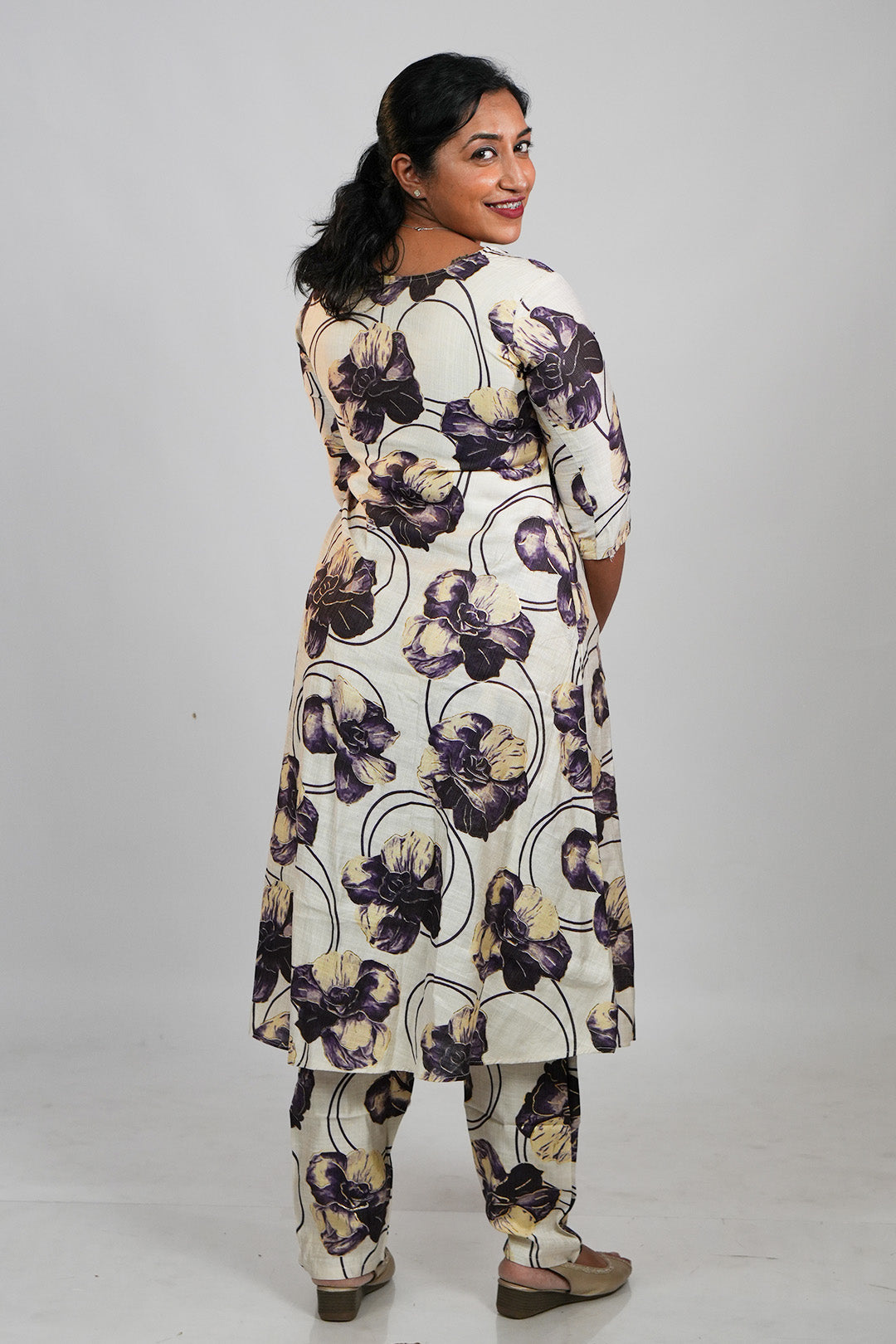 Woman in Aroha Orchid Muse co-ord set posing with an over the shoulder look