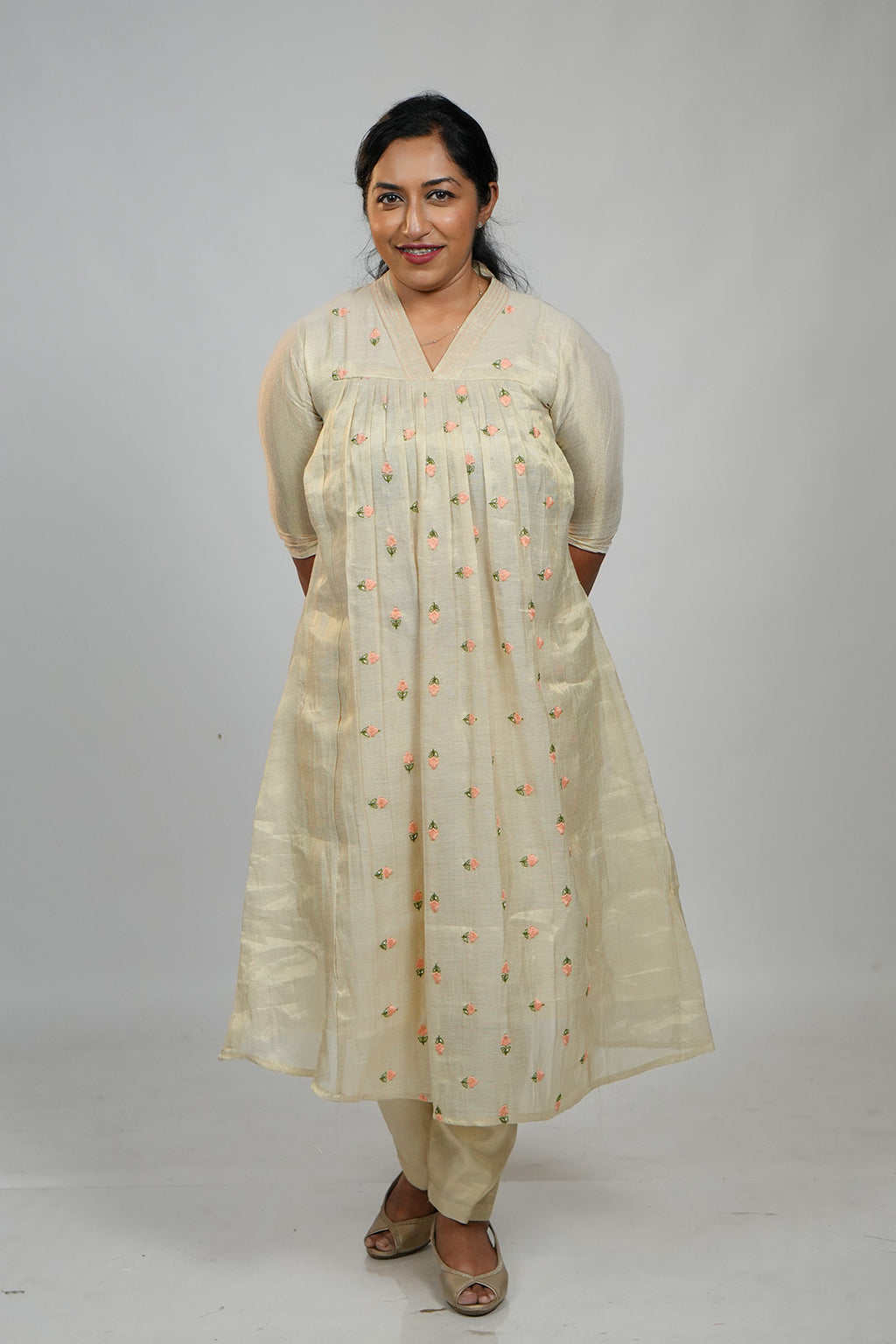 Woman in Aroha Peach Whisper co-ord set standing with hands clasped behind her back