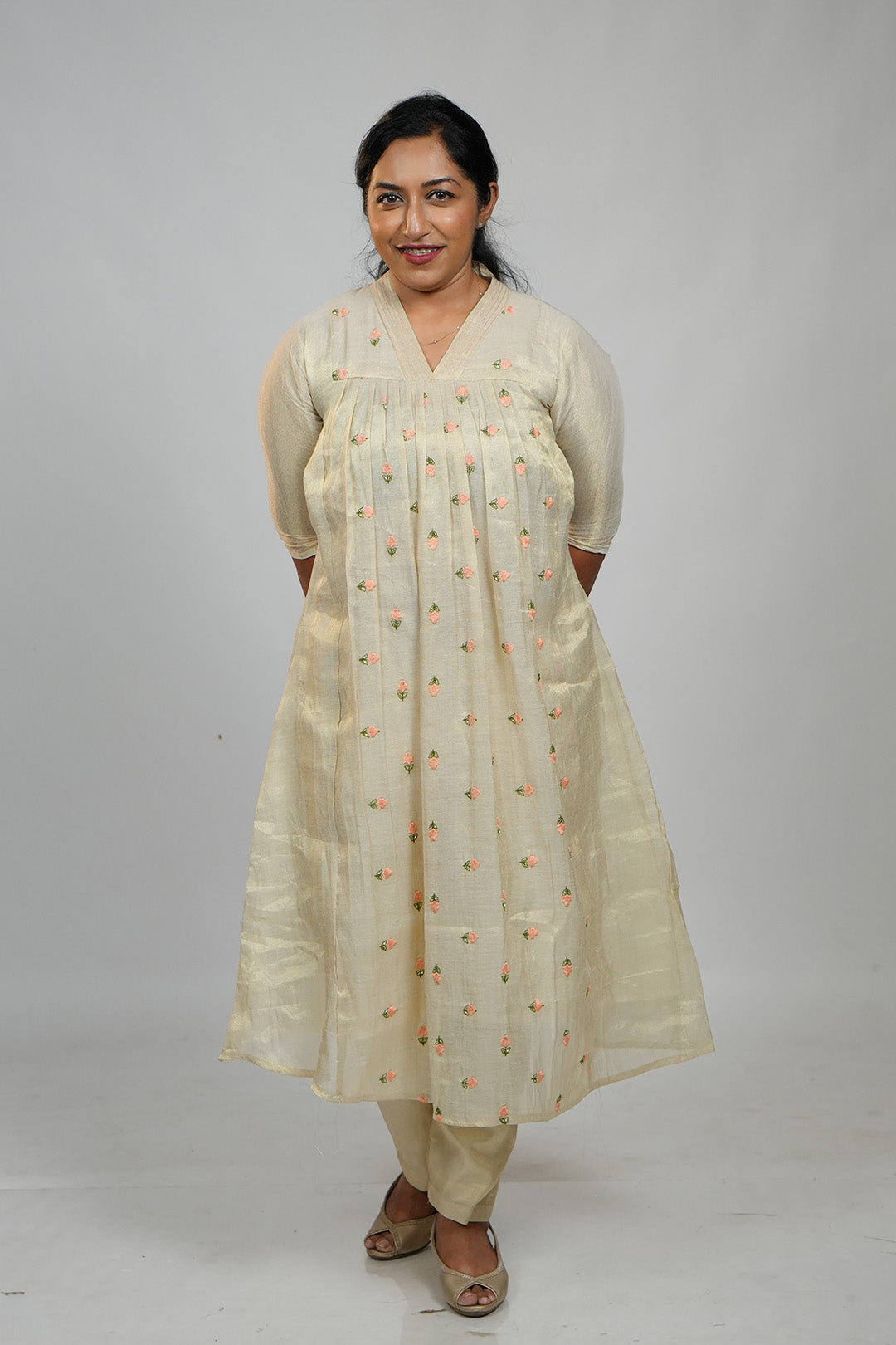 Woman in Aroha Peach Whisper co-ord set standing with hands clasped behind her back