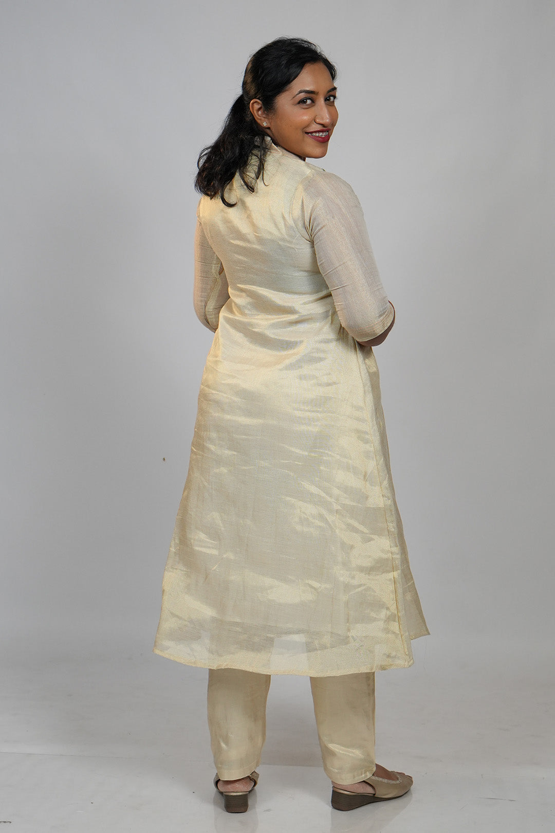 Woman in Aroha Peach Whisper co-ord set posing with an over the shoulder look