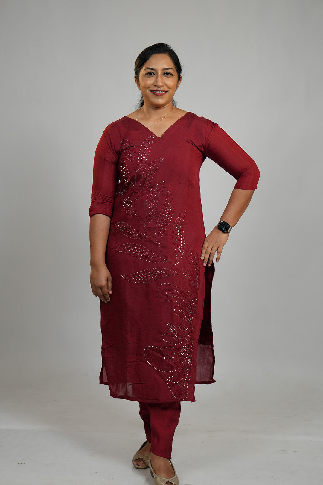 Woman standing in Aroha Ruby Grace maroon co-ord set in a minimal queen pose