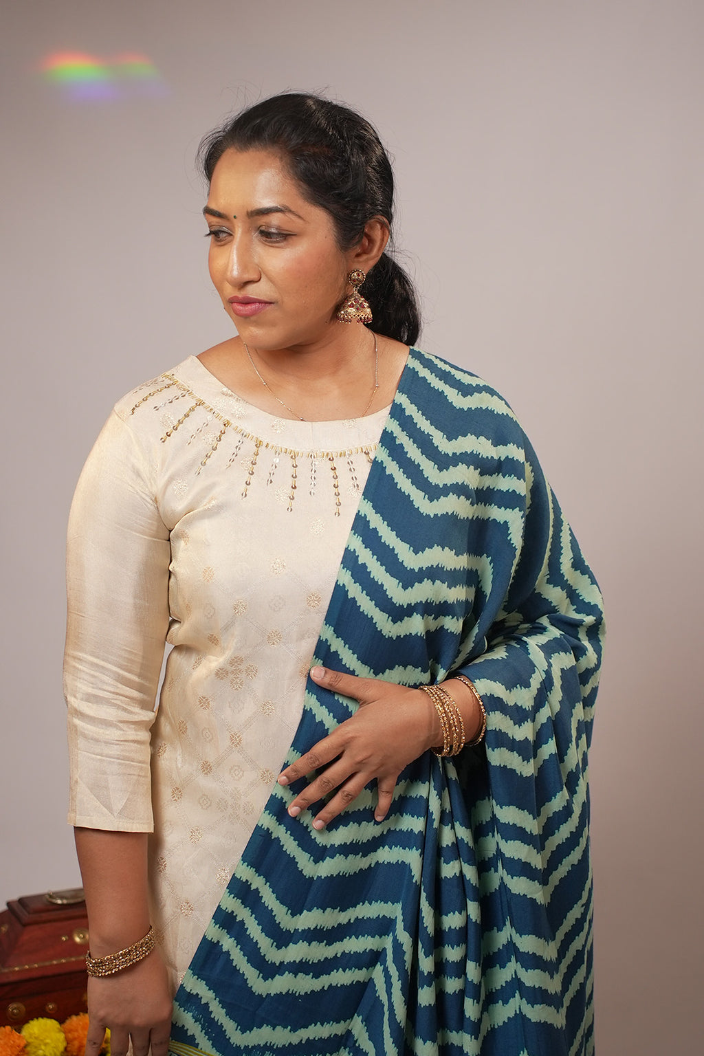 Close up of woman in Aroha Sea Breeze co-ord set looking away with soft light flare