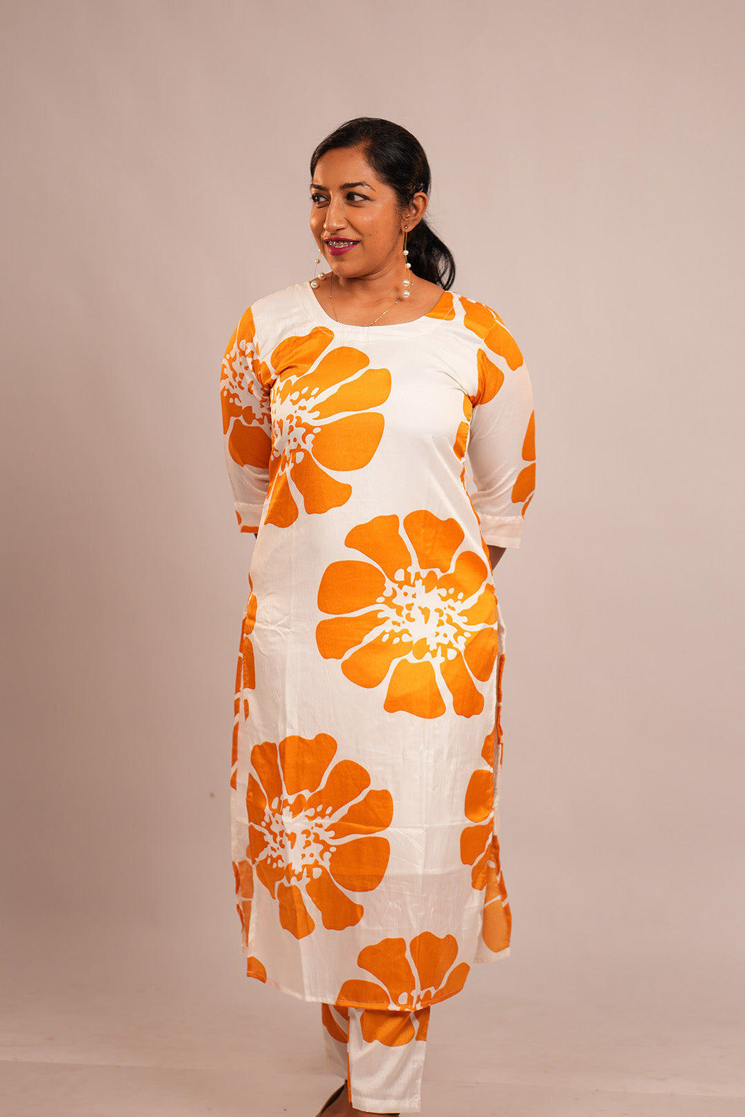 Woman in Aroha Sunflower co-ord set standing with hands clasped behind her back