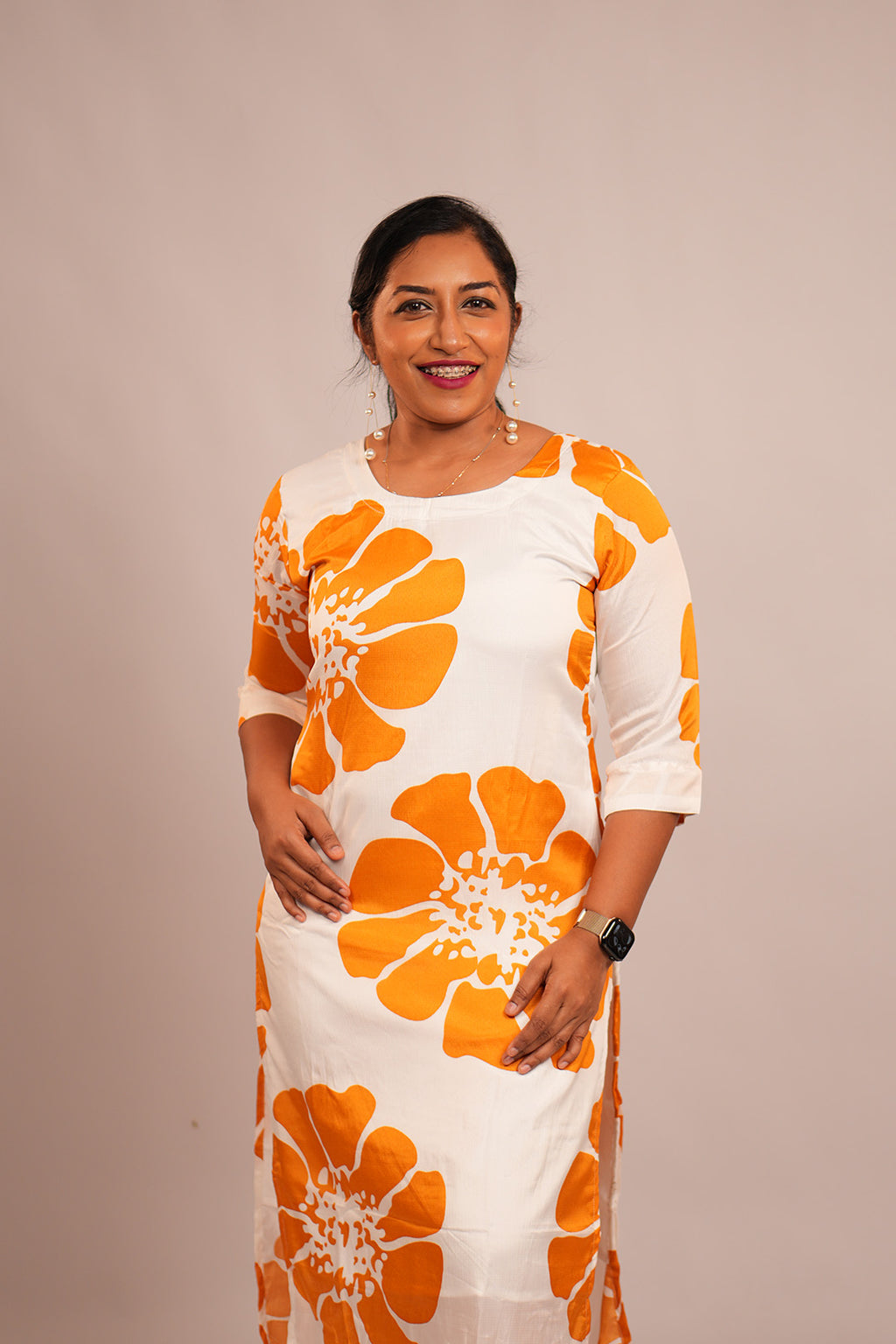 Woman standing in Aroha Sunflower white co-ord set with orange floral print